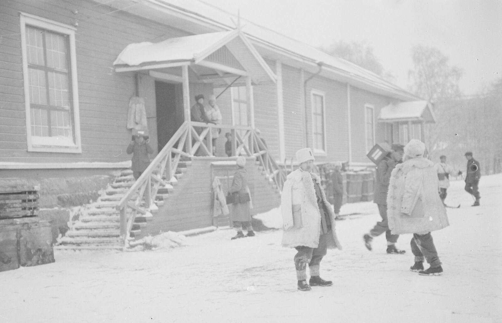 Swedish volunteers in winter coats outside a wooden building in Kemi, Finland, on January 8, 1940